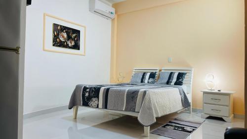 ein Schlafzimmer mit einem Bett und einem Bild an der Wand in der Unterkunft Arena coco & playa in Boca Chica