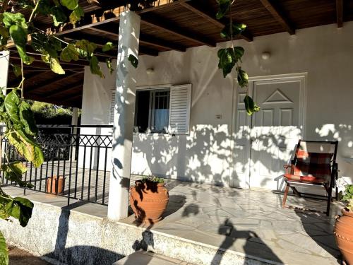 a porch of a house with a chair and a fence at Rest & Relax holiday house in Katakolo in Katakolon