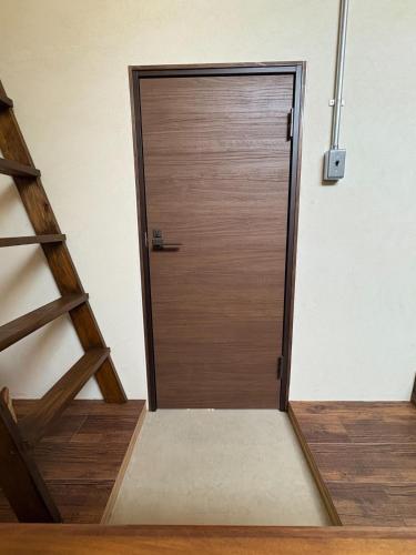 a wooden door in a room with a staircase at Sakaeya - Vacation STAY 76435v in Oshima