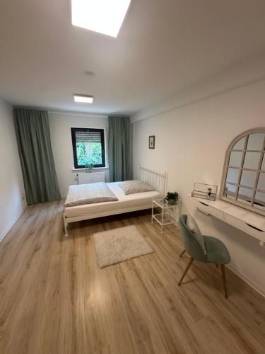 a bedroom with a bed and a window and a chair at Waldzeit Apartment Natur Komfort und Self Check-in in Neustadt an der Weinstraße