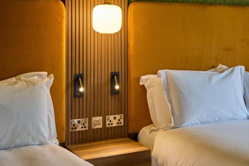 a hotel room with two beds and a lamp at Hazel Tree Lodge Bunclody in Bunclody