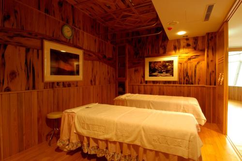 烏來區的住宿－日月民宿，木墙客房的两张床