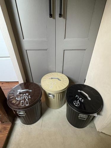 three trash cans sitting in front of a door at Sakaeya - Vacation STAY 76435v in Oshima