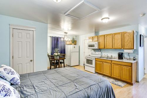 a bedroom with a bed and a kitchen with a table at Walkable Paradise Downtown Puyallup Studio! in Puyallup