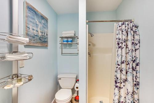a bathroom with a toilet and a shower curtain at Walkable Paradise Downtown Puyallup Studio! in Puyallup
