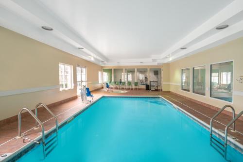 a large pool with blue water in a building at La Quinta by Wyndham Latham Albany Airport in Latham