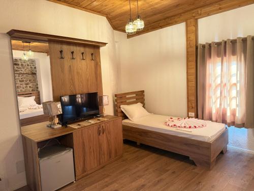 a bedroom with a bed and a tv and a mirror at Hotel Borklad in Berat