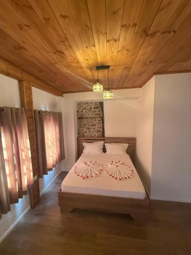 a bedroom with a bed with a wooden ceiling at Hotel Borklad in Berat