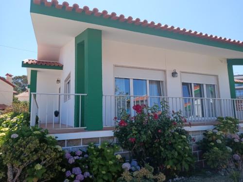 a house with a green and white at Villa Vitória in Nazaré