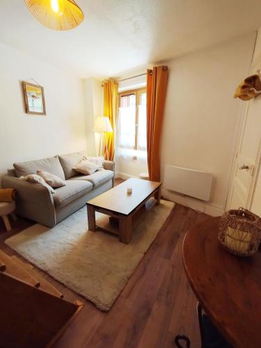 a living room with a couch and a coffee table at Maison de charme au cœur d'Ax-Les-Thermes in Ax-les-Thermes