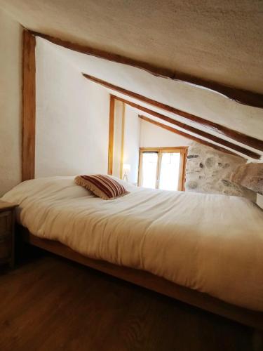 a large bed in a room with a window at Maison de charme au cœur d'Ax-Les-Thermes in Ax-les-Thermes