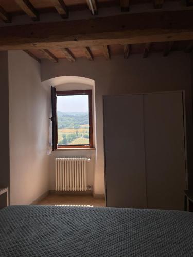 a bedroom with a bed and a window at Il Nido di Poppi in Poppi