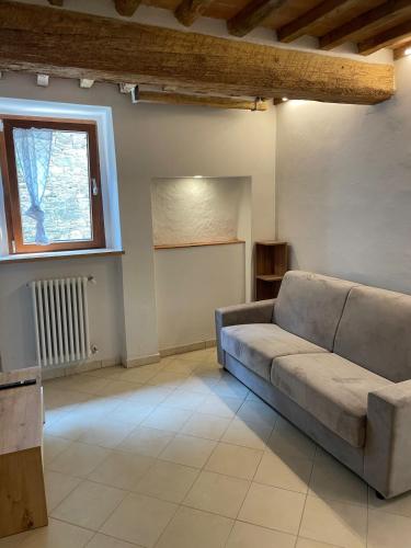 a living room with a couch and a window at Il Nido di Poppi in Poppi