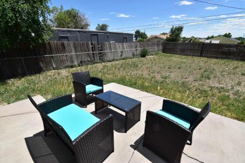 patio con 3 sedie, tavolo e recinzione di Dog Friendly and Family Sized Home in Denver Perfect for Your Furry Friend a Denver