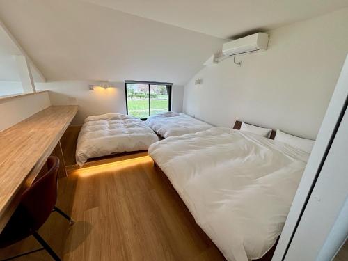 two beds in a small room with a desk at Kinagashi Happo Chalet - Vacation STAY 23528v in Hakuba