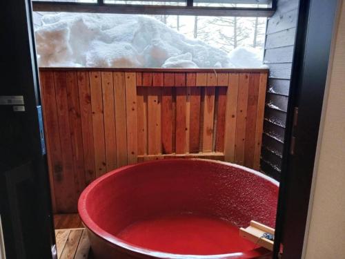 a red bath tub in a room with snow at Kinagashi Happo Chalet - Vacation STAY 23528v in Hakuba