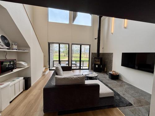 a living room with a couch and a tv at Kinagashi Happo Chalet - Vacation STAY 23528v in Hakuba