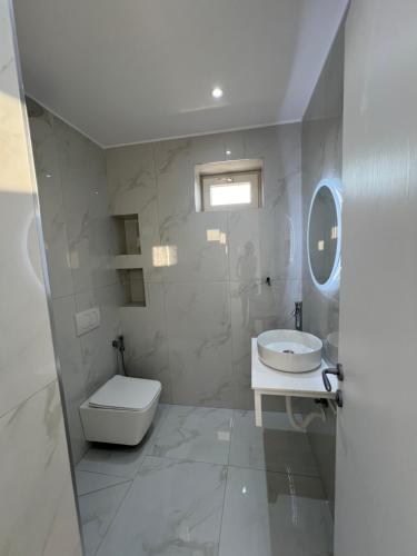 Un baño blanco con inodoro y lavabo. en Break Room Dea, en Draç