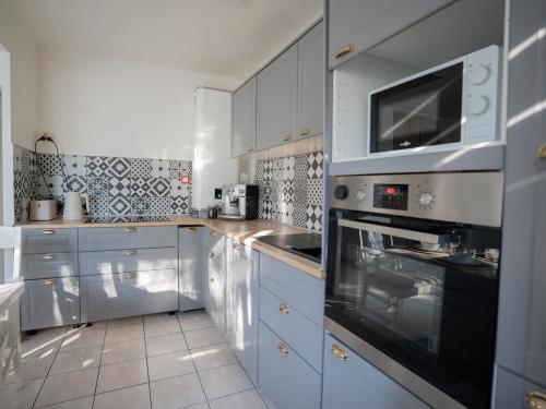 a kitchen with white cabinets and a stove top oven at Appartement Strasbourg in Strasbourg