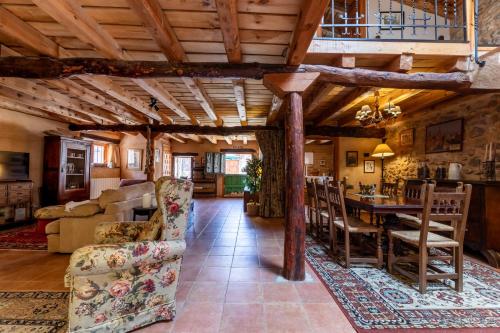 a dining room and living room with wooden ceilings at Casa Rural El Viejo Almacén, a 20 minutos de Segovia in Losana de Pirón