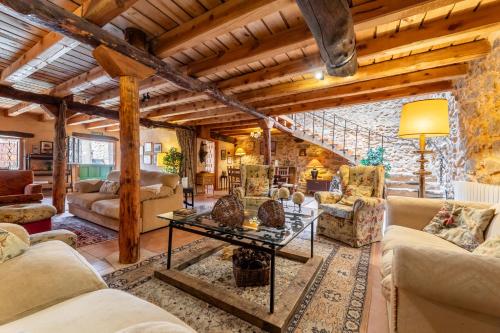 a living room with couches and a table at Casa Rural El Viejo Almacén, a 20 minutos de Segovia in Losana de Pirón