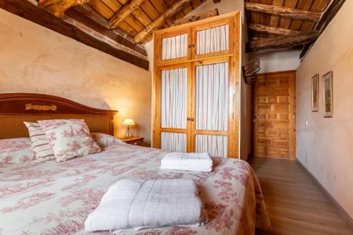 a bedroom with a bed and a large window at Casa Rural El Viejo Almacén, a 20 minutos de Segovia in Losana de Pirón