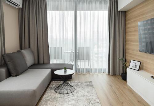 una sala de estar con un sofá y una mesa en 1BR Luxury apartment with sea view and parking space, en Varna