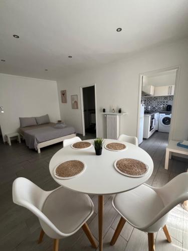 une table blanche et des chaises dans un salon dans l'établissement Studio cosy au cœur du centre ville idéal pour visiter Marseille, à Marseille