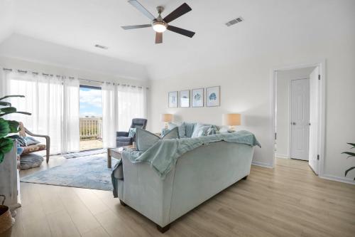 a living room with a couch and a ceiling fan at Crooked Palm - Marsh Views on Nautical Watch with pool access in Nautical Watch Villas
