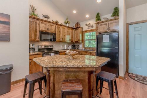 a kitchen with wooden cabinets and a island with bar stools at Hickory Hideaway with Communal Pool Access in Hollister