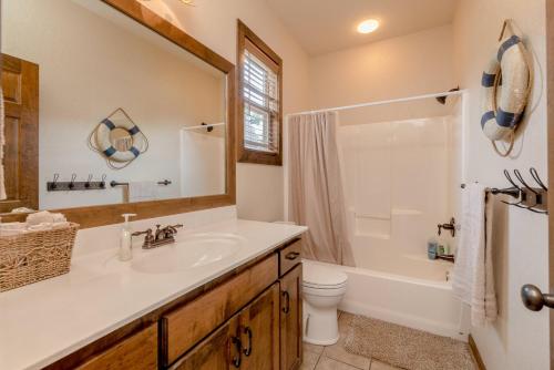 a bathroom with a sink and a toilet and a mirror at Hickory Hideaway with Communal Pool Access in Hollister