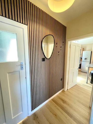 a room with a mirror on a wall with a hallway at Town Centre Waterfront Apartment in Fort William