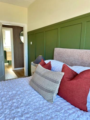 a bedroom with a bed with red and white pillows at Town Centre Waterfront Apartment in Fort William