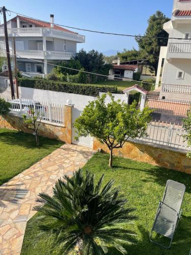 a garden with a chair and a tree and a building at Luxury Apartment in Kato Assos - Villa Orangerie in Káto Ássos