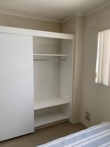 Pokój z białymi półkami i oknem w obiekcie Newmarket Apartment - Queen Bed with Private Bathroom, Free Parking Provided w Auckland
