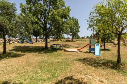 a park with a playground with trees and a slide at Casa Rural El Viejo Almacén, a 20 minutos de Segovia in Losana de Pirón