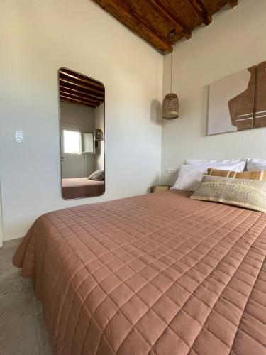 a bedroom with a large bed and a mirror at Kisari Kimolos Chorio Double Room in Kimolos