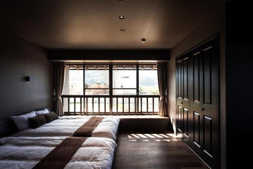 un letto in una camera con una grande finestra di Itoshima810Villa&Resort - Vacation STAY 24393v a Itoshima