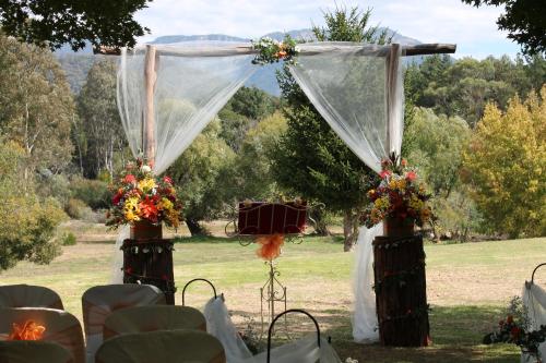 an outdoor wedding ceremony with a canopy and chairs at Buffalo Motel and Country Retreat in Porepunkah