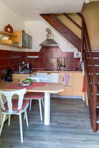 une cuisine avec une table et des chaises dans une pièce dans l'établissement Le duplex du Ried à Muttersholtz en Alsace proche Europa Park, à Muttersholtz
