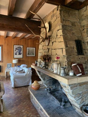 a stone fireplace in a living room with a couch at Family Cottage with a View in Mont-Louis