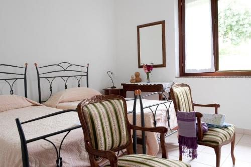 a bedroom with two beds and a table and two chairs at Il Giardino di Valentina in Escolca