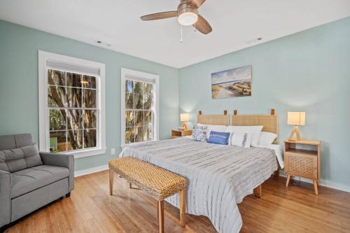 a bedroom with a bed and a couch and two windows at Oystershell Cottage in Port Royal