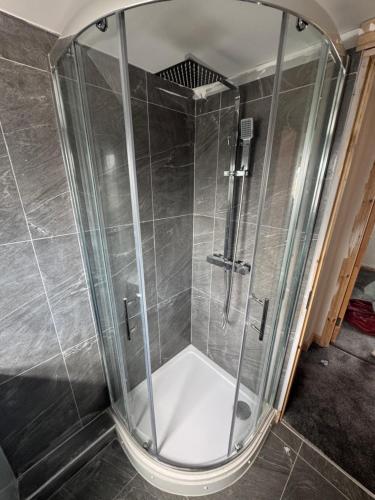 a shower with a glass enclosure in a bathroom at M12 Levenshulme luxury Guesthouse Newly Renovated in Manchester