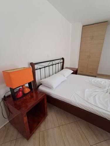 a bedroom with a bed and a table with a chair at Renting rooms in Himare
