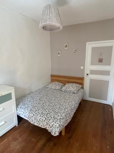 - une chambre avec un lit, une commode et une lampe dans l'établissement Grande Maison de famille patio, babyfoot, vélos, wifi, à Marennes