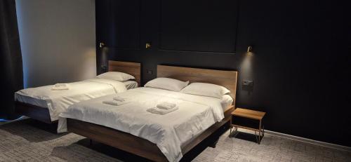 two beds in a room with white sheets at villa gardens in K'obulet'i