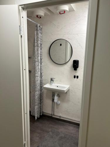 a bathroom with a sink and a mirror at Övernattningsrum in Varberg