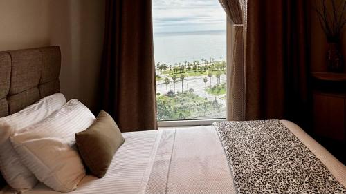 a bedroom with a bed with a view of the ocean at Stylish apartments White Sails View in Batumi