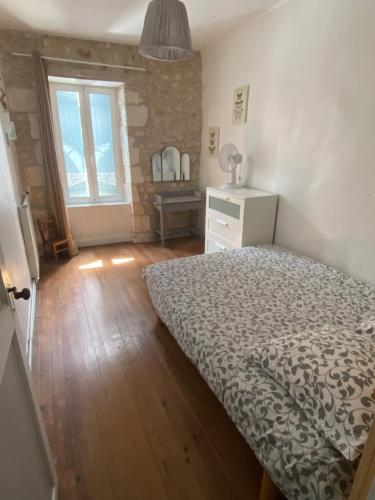 une chambre avec un lit et un parquet dans l'établissement Grande Maison de famille patio, babyfoot, vélos, wifi, à Marennes